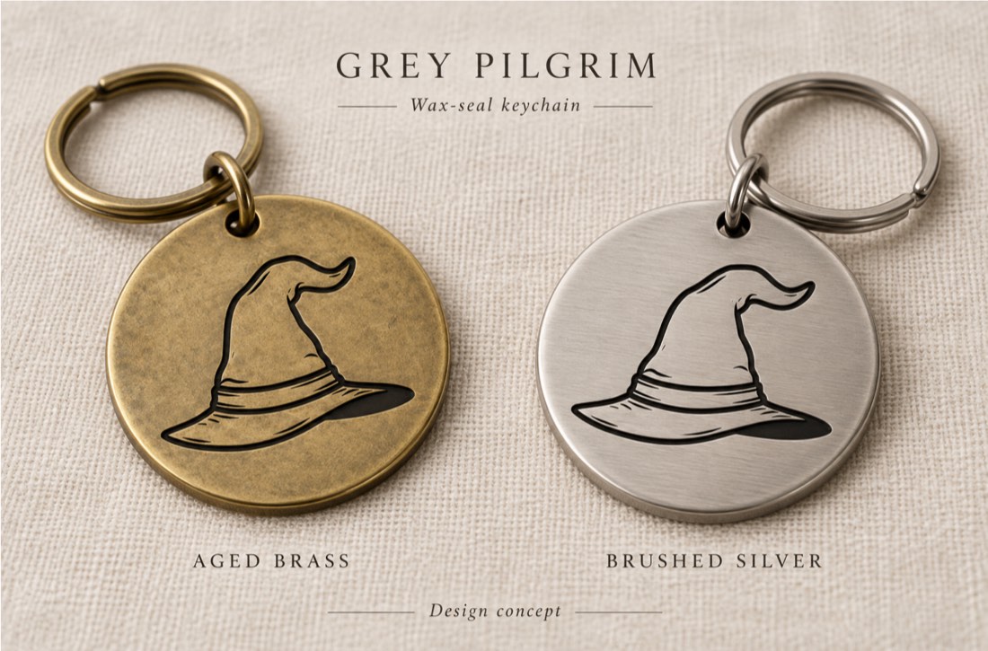 Wax-seal keychains — the hat mark engraved on round tags in aged brass and brushed silver